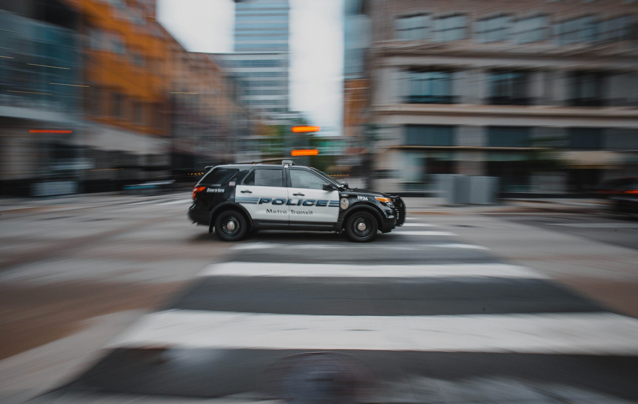 josh-hild-zXJLN5Niplw-unsplash Police car driving.
